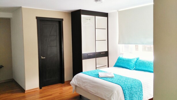 Un dormitorio con cama, armario y puerta.
