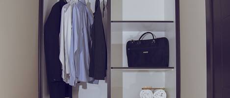 Un dressing avec espace pour suspendre les vêtements, des étagères pour les sacs et les chaussures, et des tiroirs.