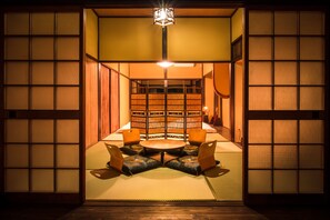 Une pièce de style japonais traditionnel, avec un sol recouvert de tatamis, une table basse et des coussins.