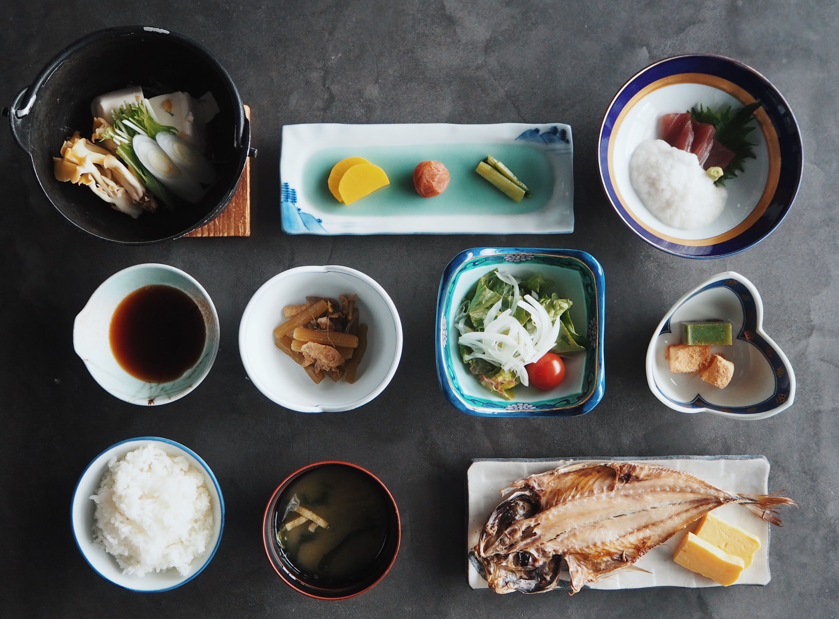 Une variété de plats, notamment du poisson, du riz et des légumes, disposés sur une table.