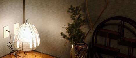 Une pièce avec une table en bois, une lampe, un tableau encadré et une petite plante en pot.