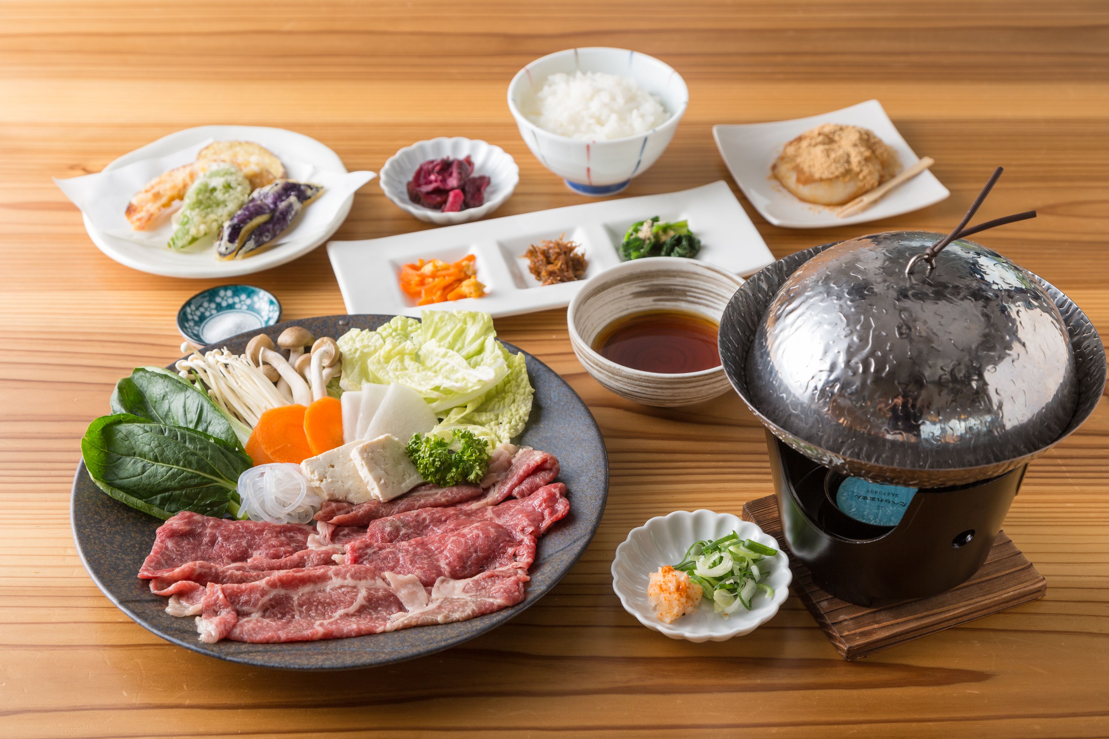 A traditional Japanese meal setup with various dishes and a hot pot.