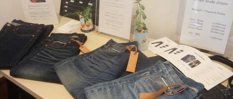 Exhibición de jeans con etiquetas de precio y un menú para ordenar jeans a medida.