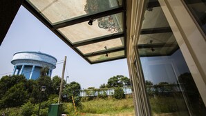 A view through a glass ceiling with a water tower in the background. - backpackers.INN (Jinning)