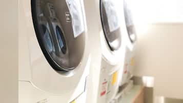 A row of front-loading washing machines in a commercial setting.