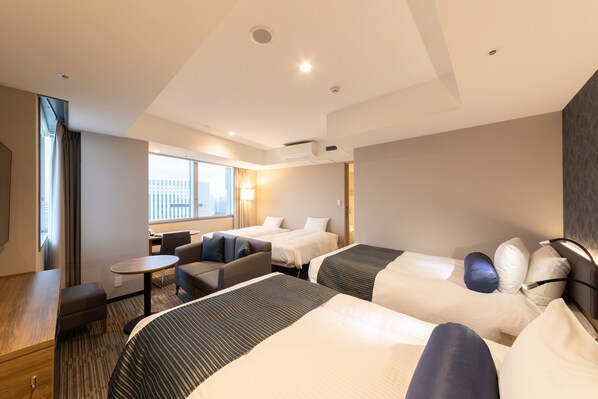 A hotel room with two beds, a sofa, a small table, and a window with curtains. - KEIKYU EX INN Haneda (Tokyo)