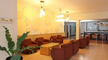 A lobby with seating, a reception desk, and a wall with circular patterns.