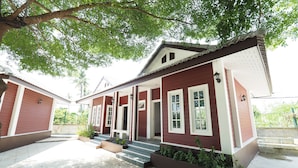 Et toetagers hus med en overdækket veranda og en fliseterrasse.