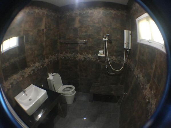 Een badkamer met toilet, wastafel en douche.