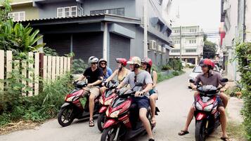 A group of people on motorcycles parked on a narrow street.