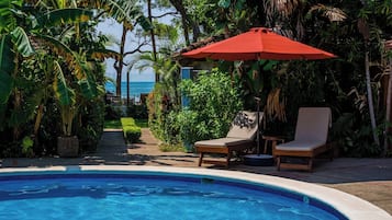 Piscine extérieure, parasols de plage, chaises longues