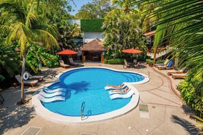 Een buitenzwembad, parasols bij het zwembad en ligstoelen