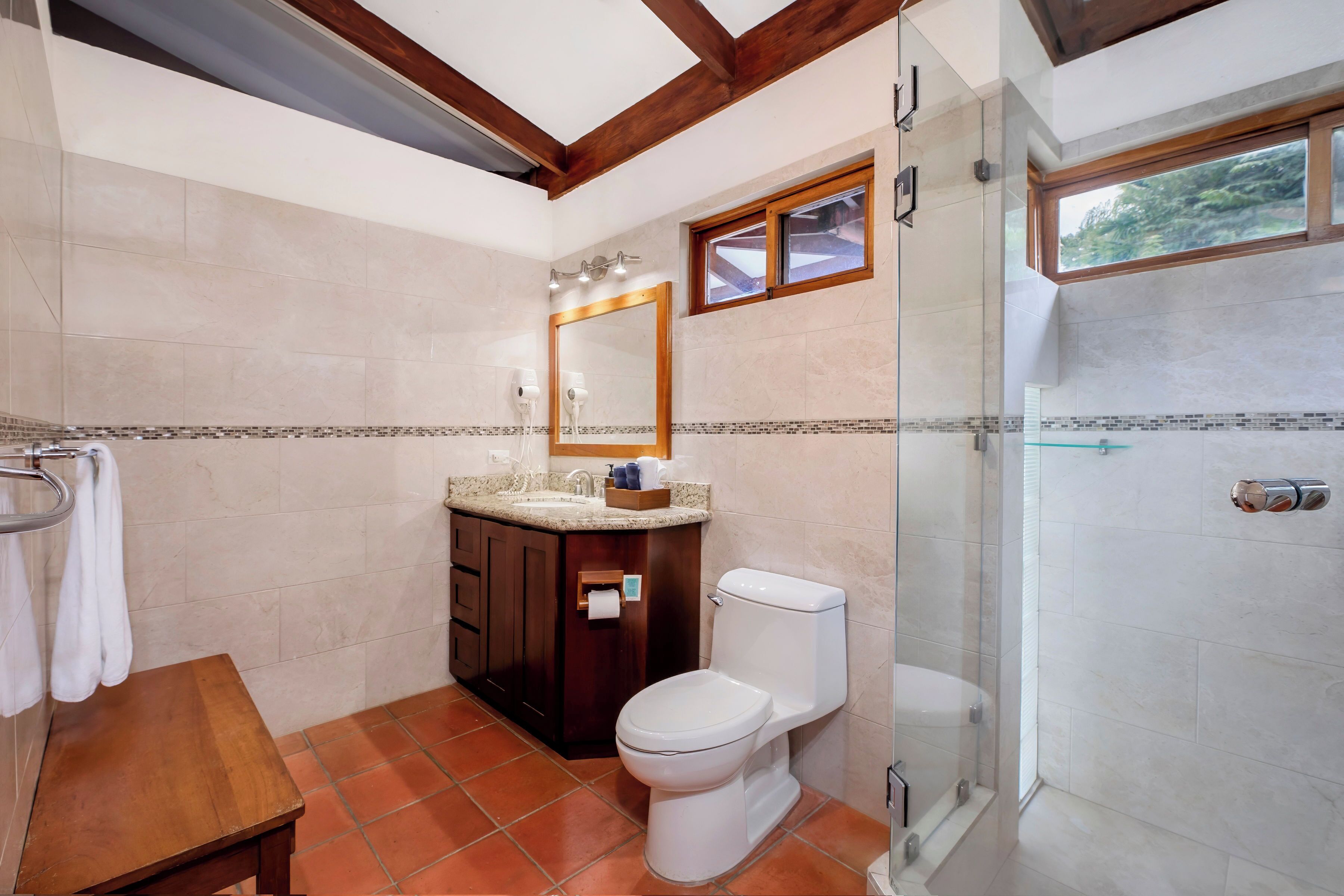 A modern bathroom with a toilet, sink, and shower.