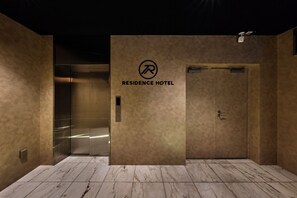 An elevator with a sign reading 'RESIDENCE HOTEL' and a control panel with a button. - Residence Hotel Hakata 3 (Fukuoka)