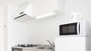 Una cocina moderna con armarios blancos, horno empotrado, microondas y estufa.
