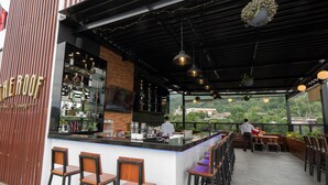 Un espace bar avec un comptoir, des tabourets et une vue sur la verdure.