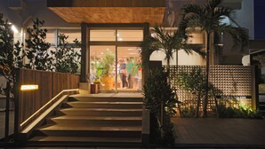 Une entrée moderne, avec un escalier en bois menant à une porte en verre.