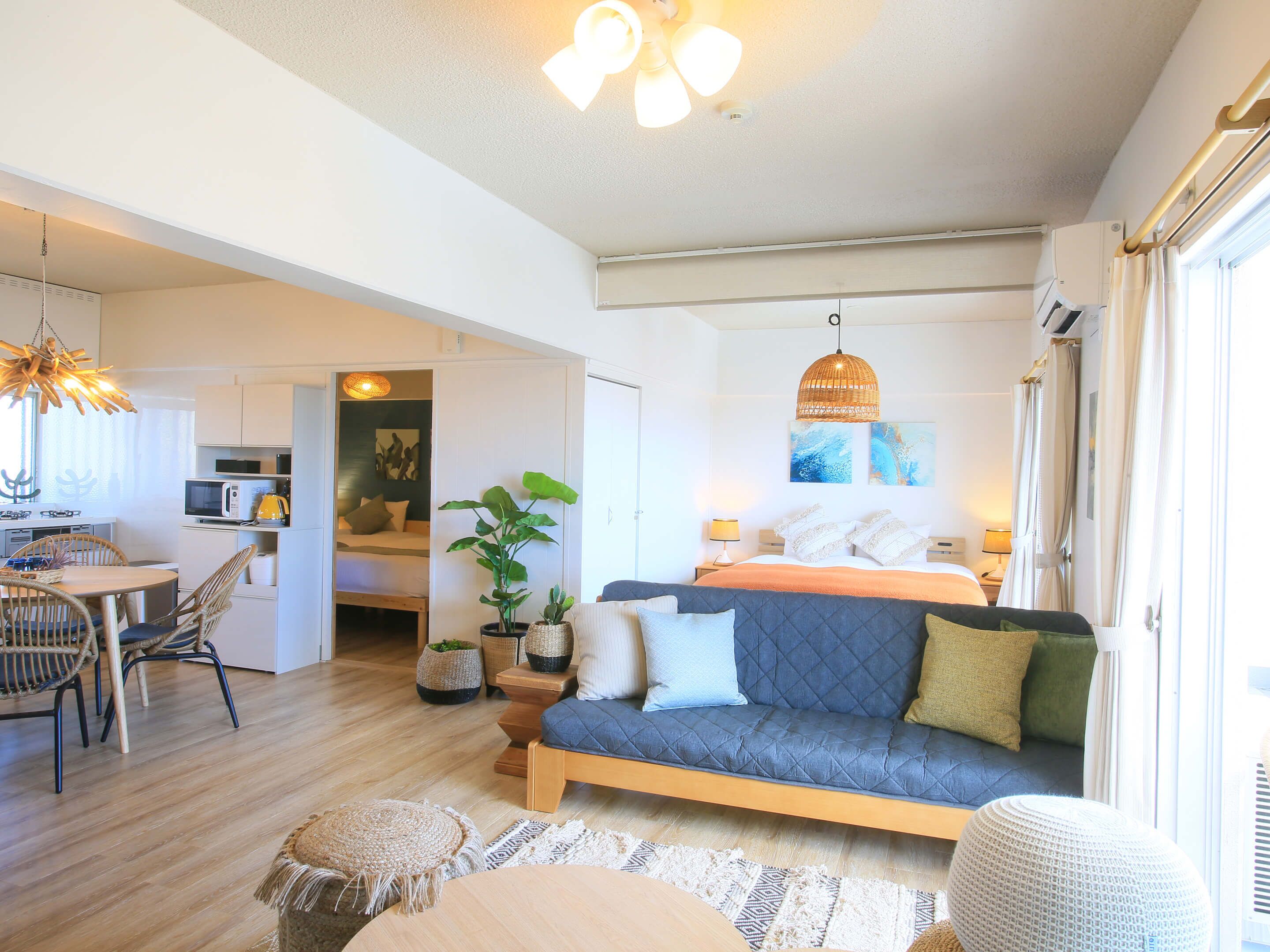 A modern, well-lit room with a sofa, dining table, and kitchen area.