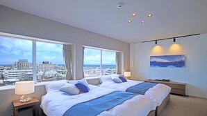 Une chambre d’hôtel avec un grand lit, deux tables de chevet, une commode, une lampe, un tableau et une vue sur le paysage urbain.