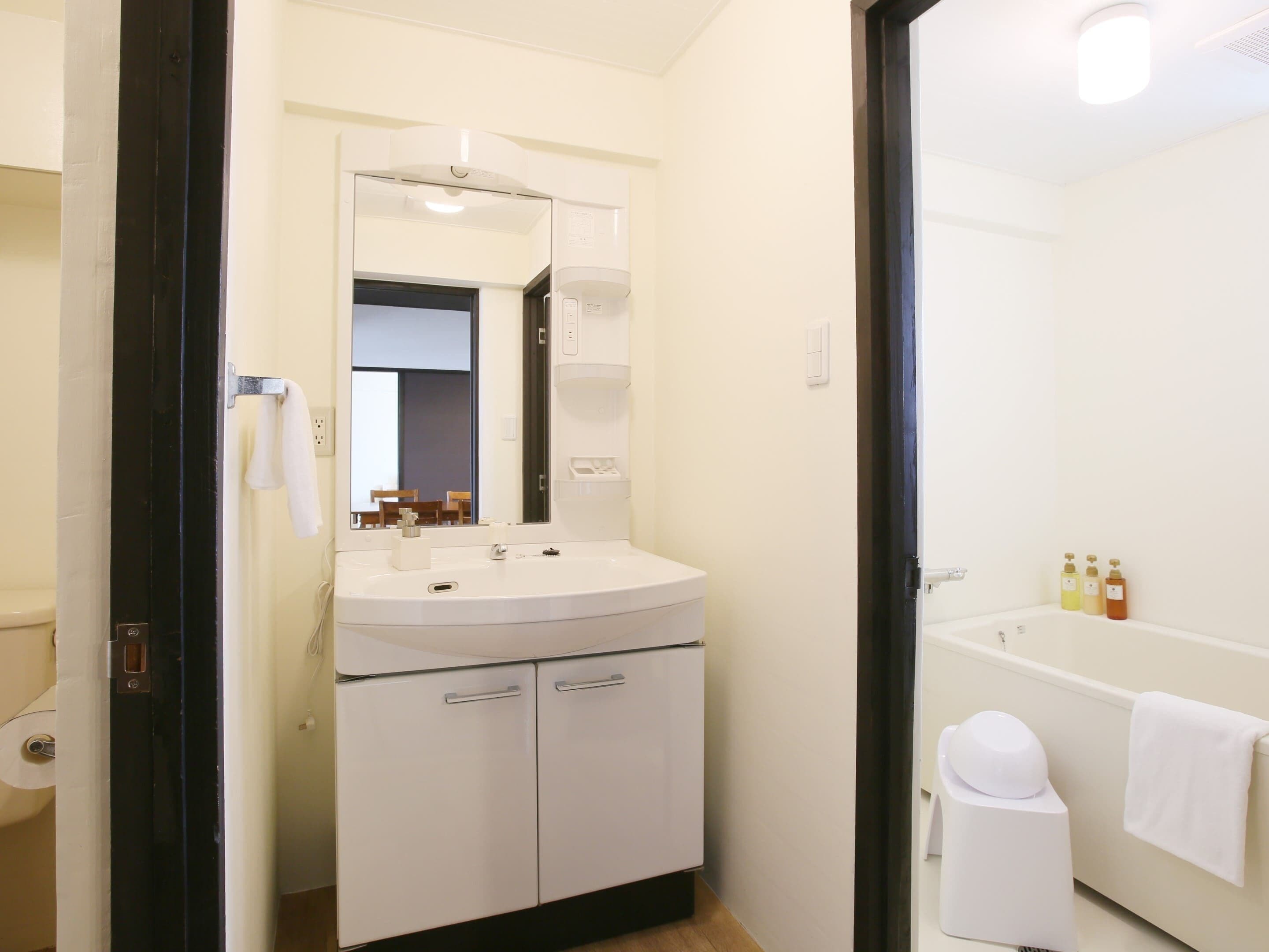 Un baño con lavamanos, espejo e inodoro.