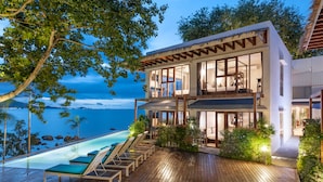A modern two-story house with a wooden deck, a pool, and a view of the ocean. - Tamarina Bed & Beyond (Koh Samui)