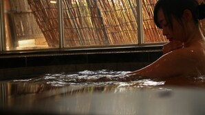 A person in a hot tub with bamboo blinds in the background. - Masuya Ryokan (Izumo)