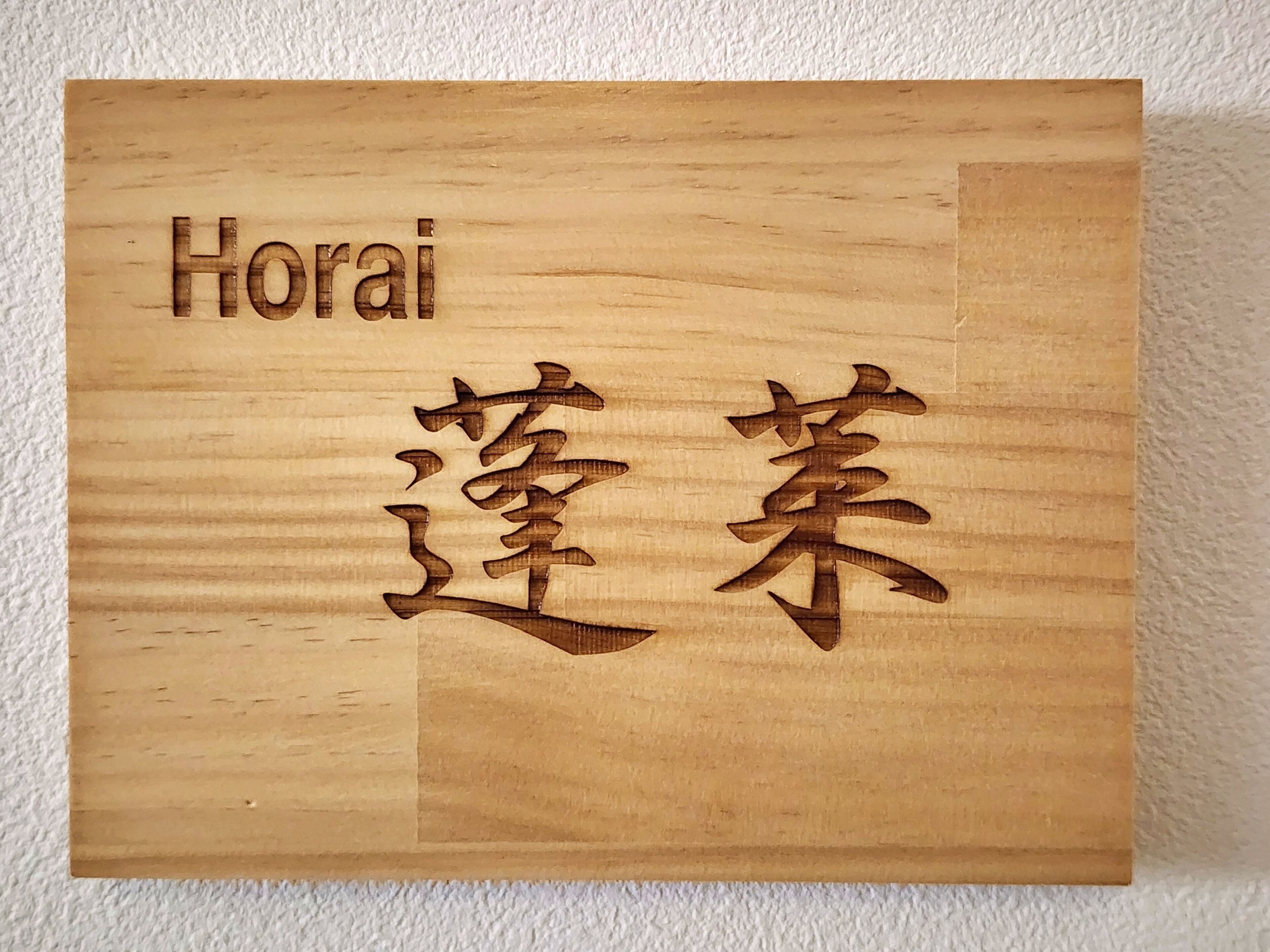 A wooden plaque with the name "Horai" and Japanese characters.