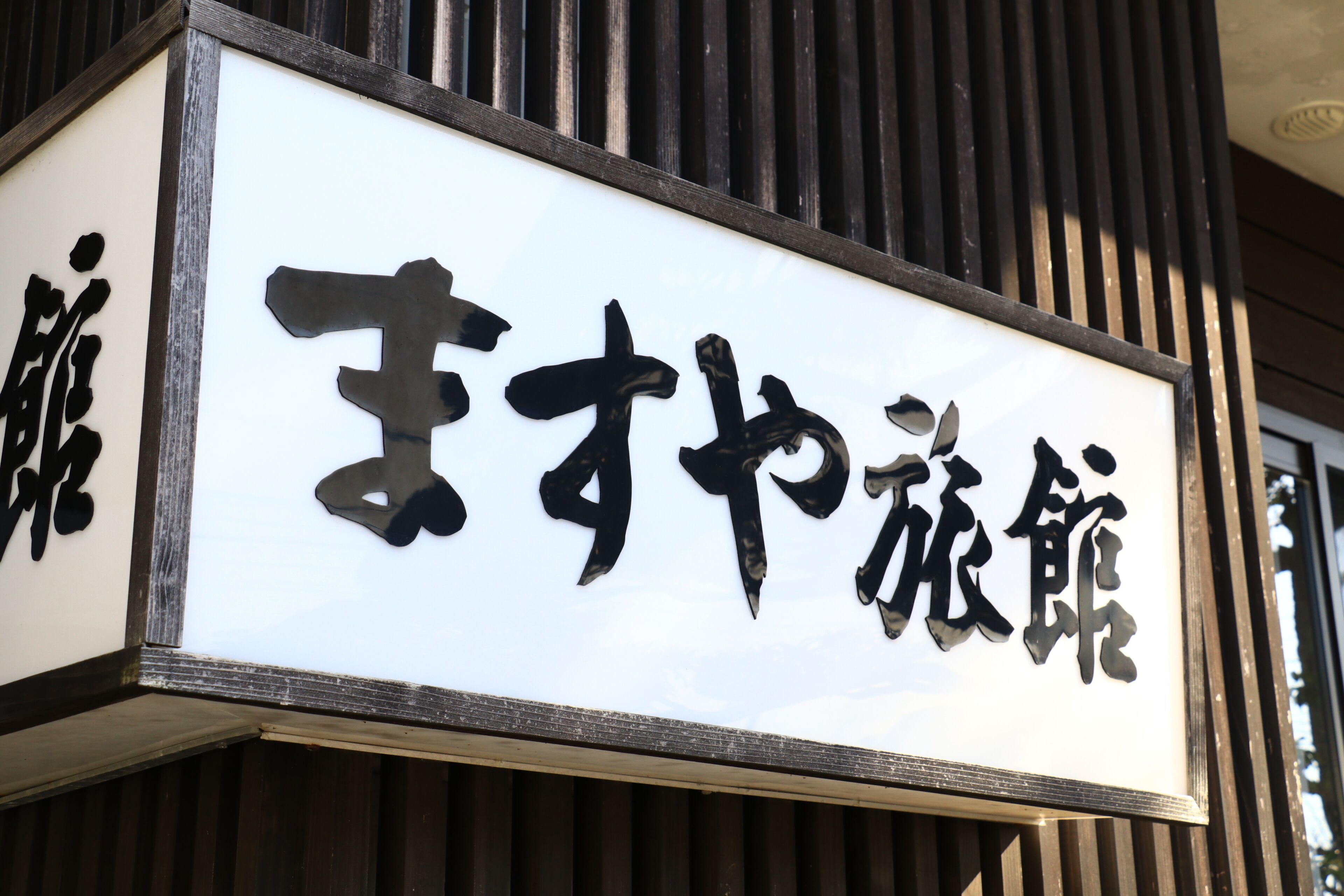 A sign with Japanese characters on a building facade.