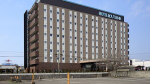 A multi-story hotel with a modern design, featuring a prominent sign at the top. - Hotel Route Inn Ube (Ube)