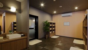 A modern bathroom with a large mirror, a sink, and a potted plant. - Hotel Route Inn Ube (Ube)