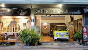 A boutique guest house named 'Satta Hipale' with a yellow car parked in front, potted plants, and a lifebuoy on the wall. - Sattahiptale Boutique Guest House & Hostel (Sattahip)