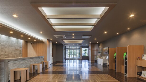 A modern lobby with a reception desk, seating area, and a view of the outdoors. - Hotel Route - Inn Kumagaya (Kumagaya)