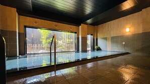 A spacious indoor swimming pool with clear glass walls, a tiled floor, and a wooden ceiling. - Hotel Route - Inn Kumagaya (Kumagaya)
