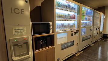 Vending machines with beverages and a microwave.