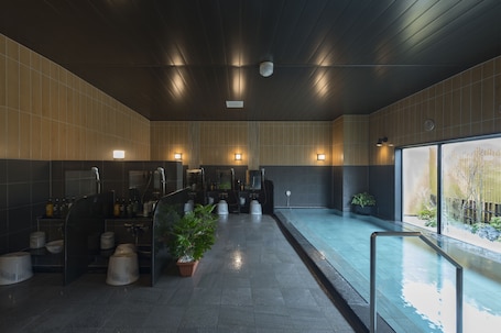 A modern bathroom with a large mirror, multiple sinks, and a small pool area.
