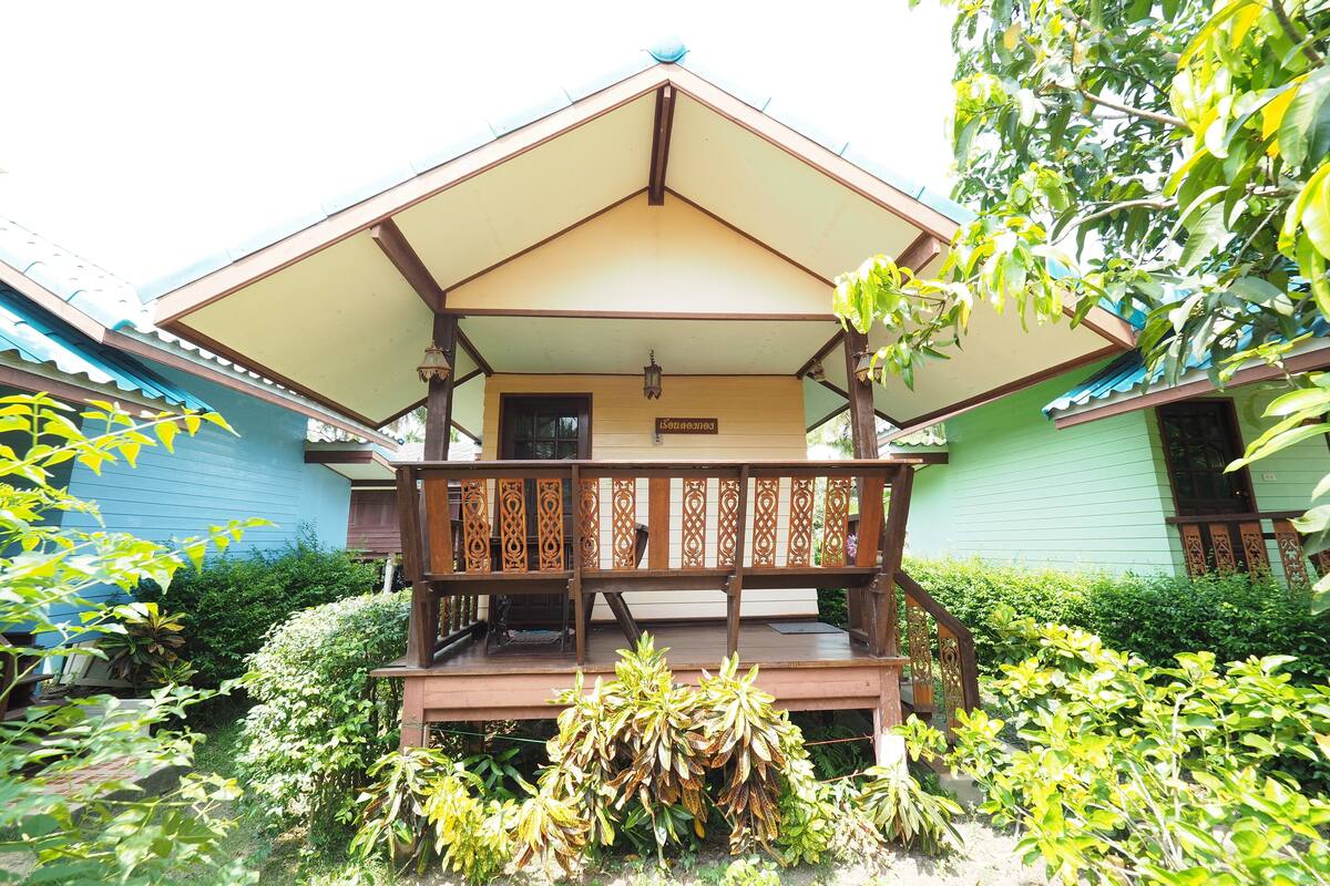 A traditional wooden house with a covered porch and a sign indicating a room number.