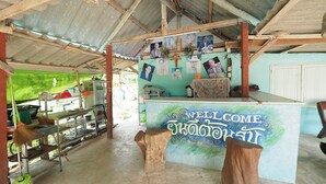 A reception area with a 'WELCOME' sign, a counter, and a wall adorned with photographs.
