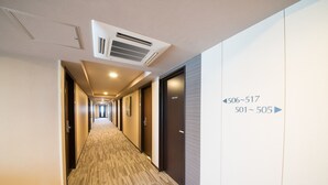 A hotel hallway with carpeted floors, doors numbered 501-505, and 506-517. - Hotel Route Inn Fujichuokoen Higashi (Fuji)