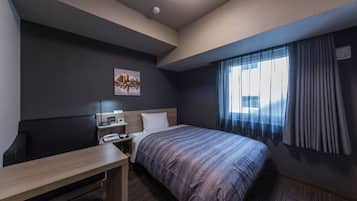 A hotel room with a bed, a desk, a chair, a nightstand, a lamp, a painting, and a window with curtains.
