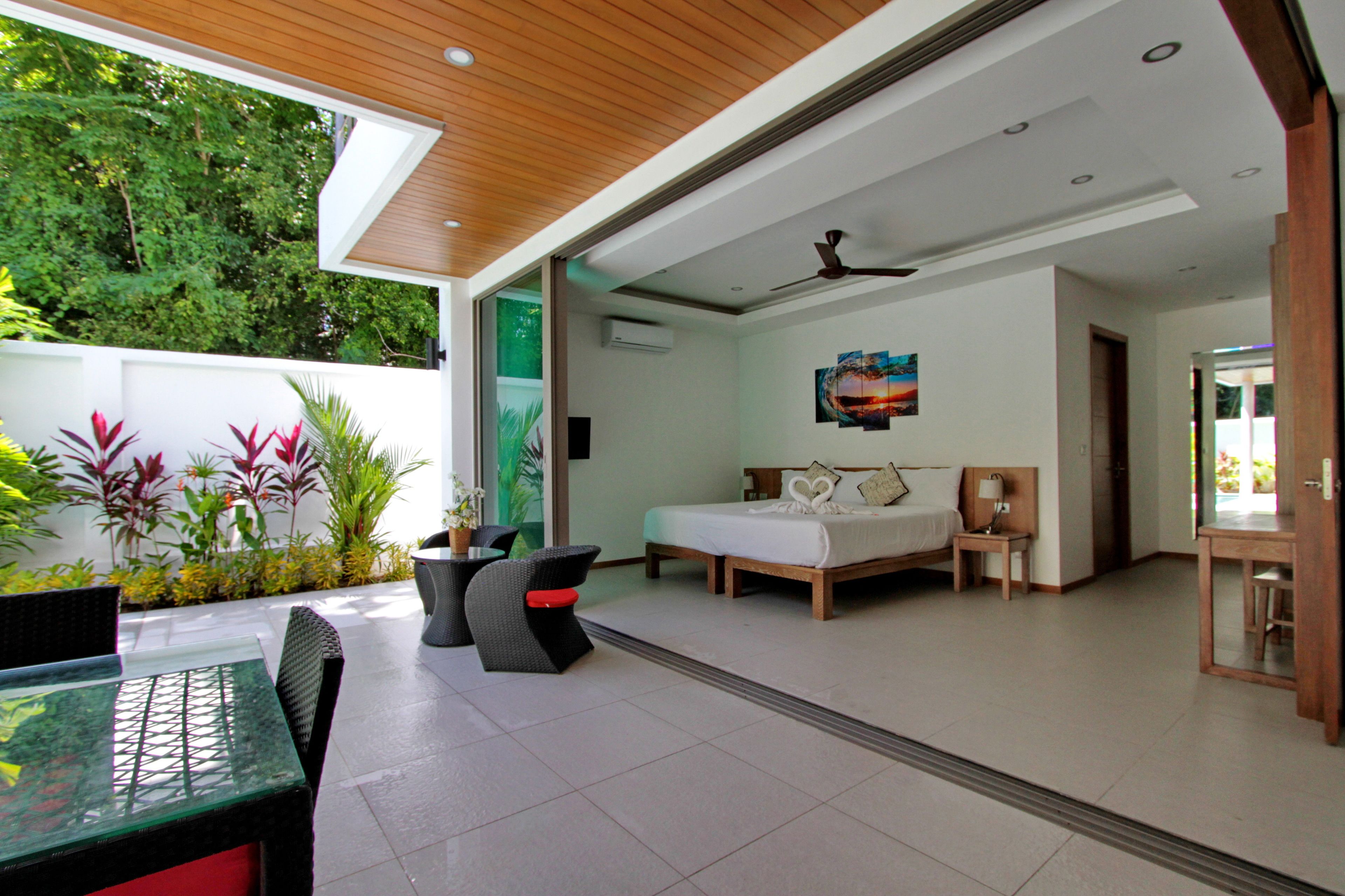 A modern hotel room with a bed, bedside table, and a view of the garden.
