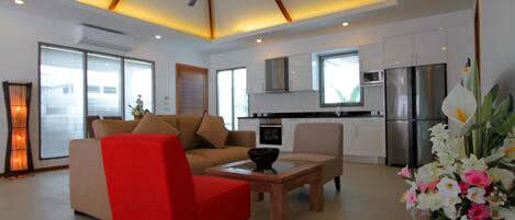 A modern living room with a sofa, red chair, and a coffee table.