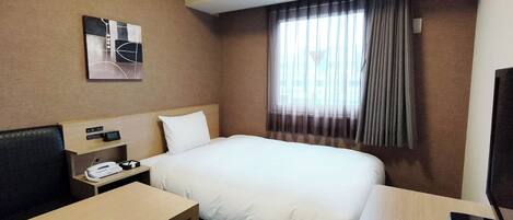 Habitación de hotel con cama, escritorio, silla, televisor, reloj y ventana con cortinas.