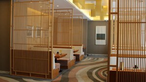 A traditional Japanese-style room with tatami mats, low wooden partitions, and a view of the cityscape. - Hotel Paris Pan-Island (Shanwei)