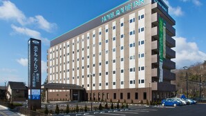 Un hôtel à plusieurs étages, reconnaissable à son enseigne bien visible indiquant « HÔTEL ROUTE INN ».