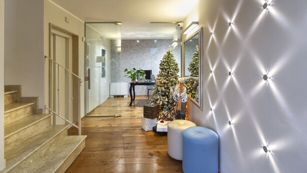 A modern interior with a staircase, a Christmas tree, and a tufted wall. - Le Dimore del Borgo (Lucca)