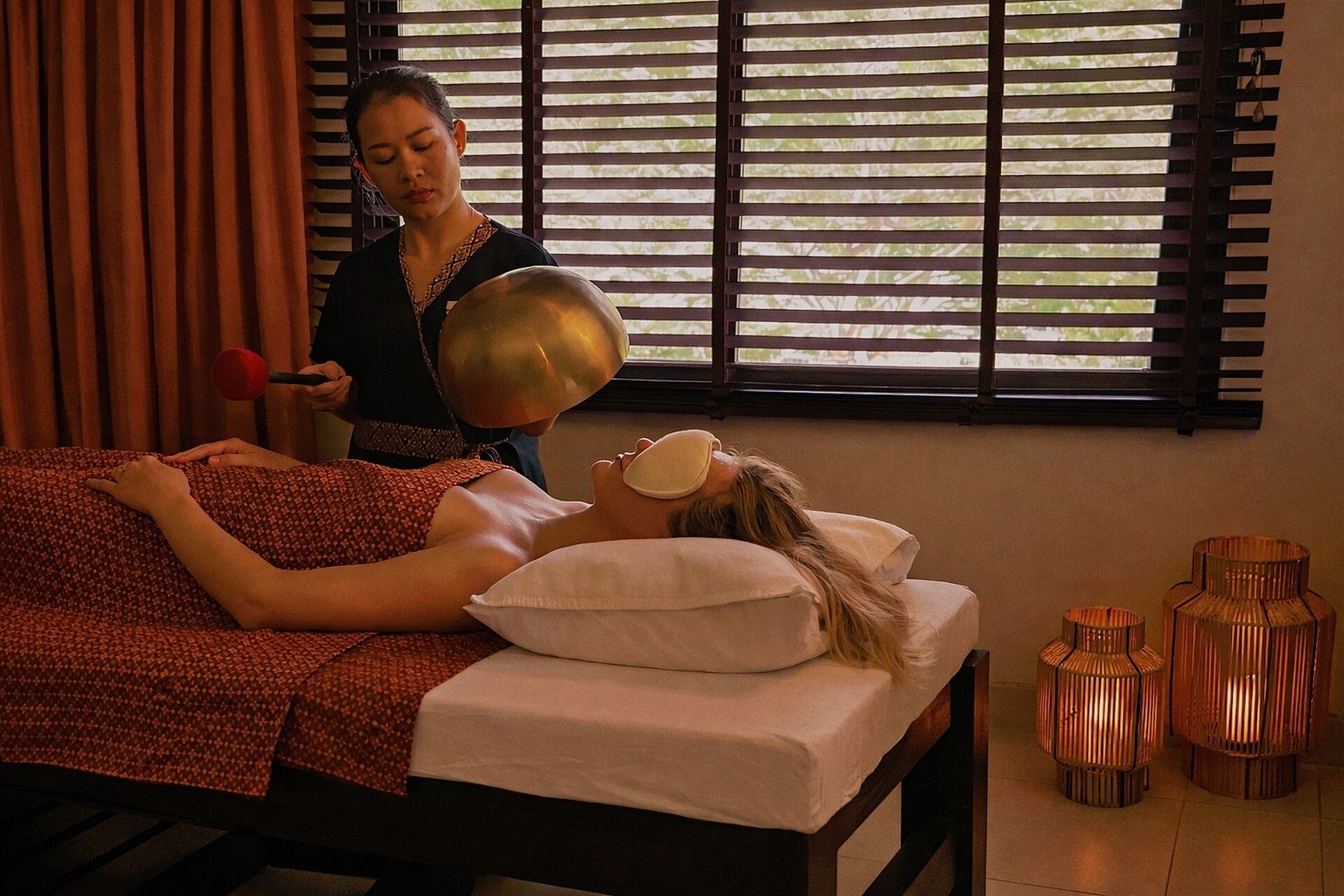Una stanza spa con un letto, un lettino da massaggio e una finestra con persiane.