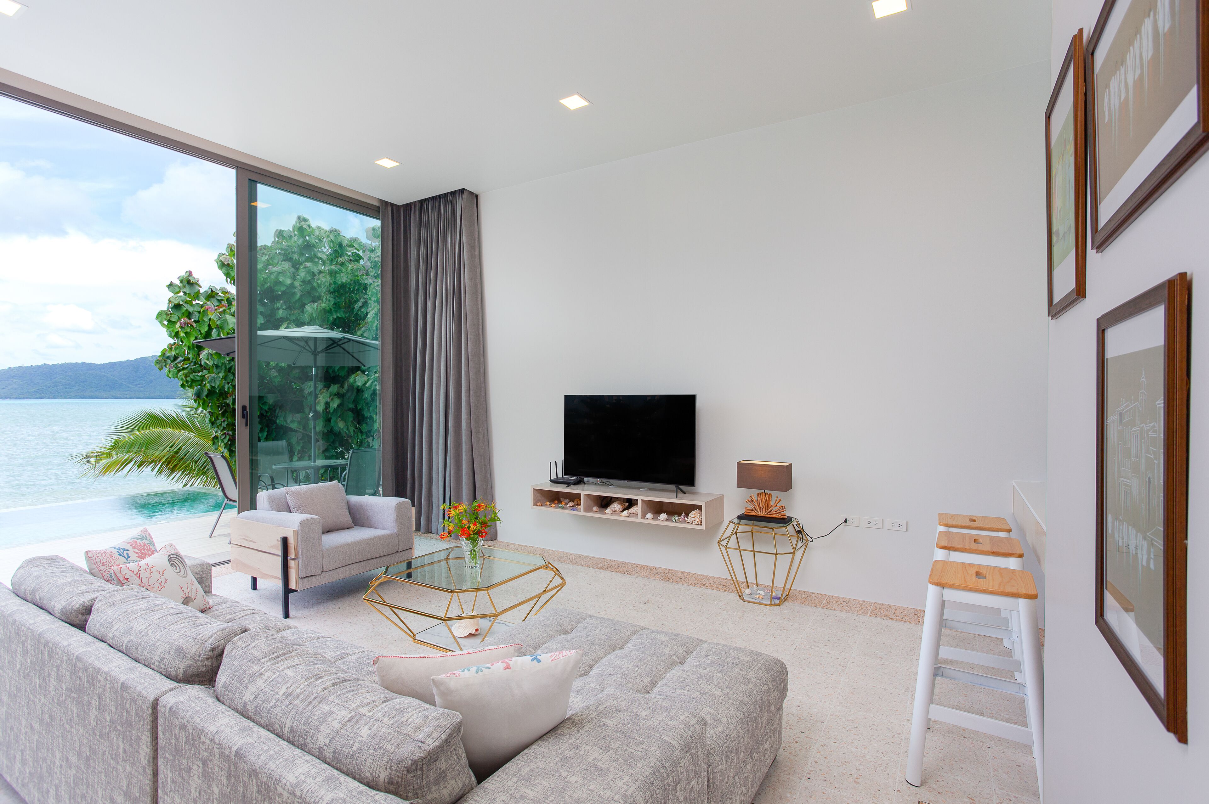 A modern living room with a large window, a flat-screen TV, a sofa, and a coffee table.