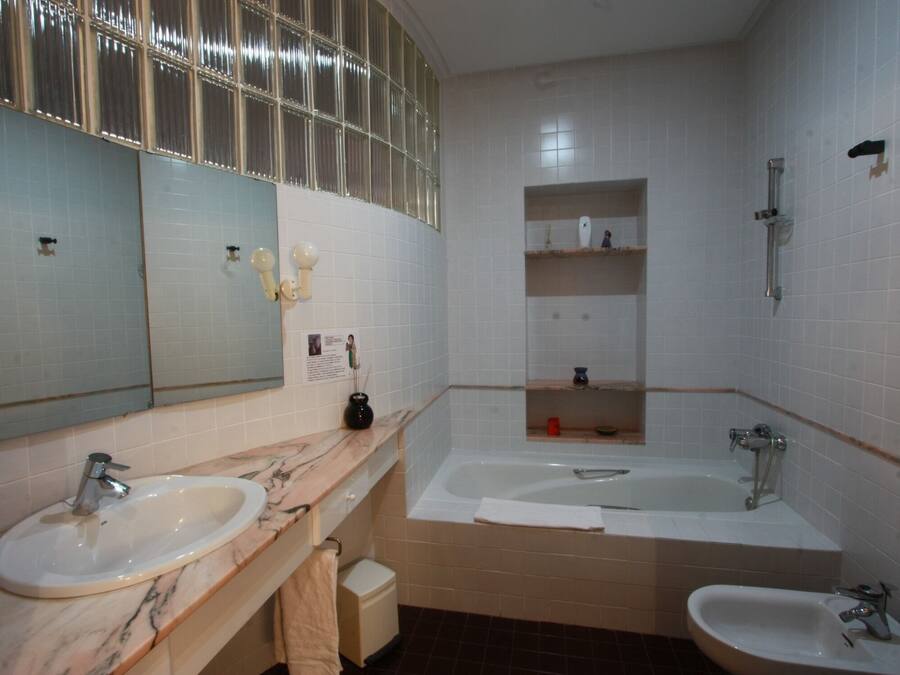Un baño con dos lavamanos, una bañera grande y una ducha.