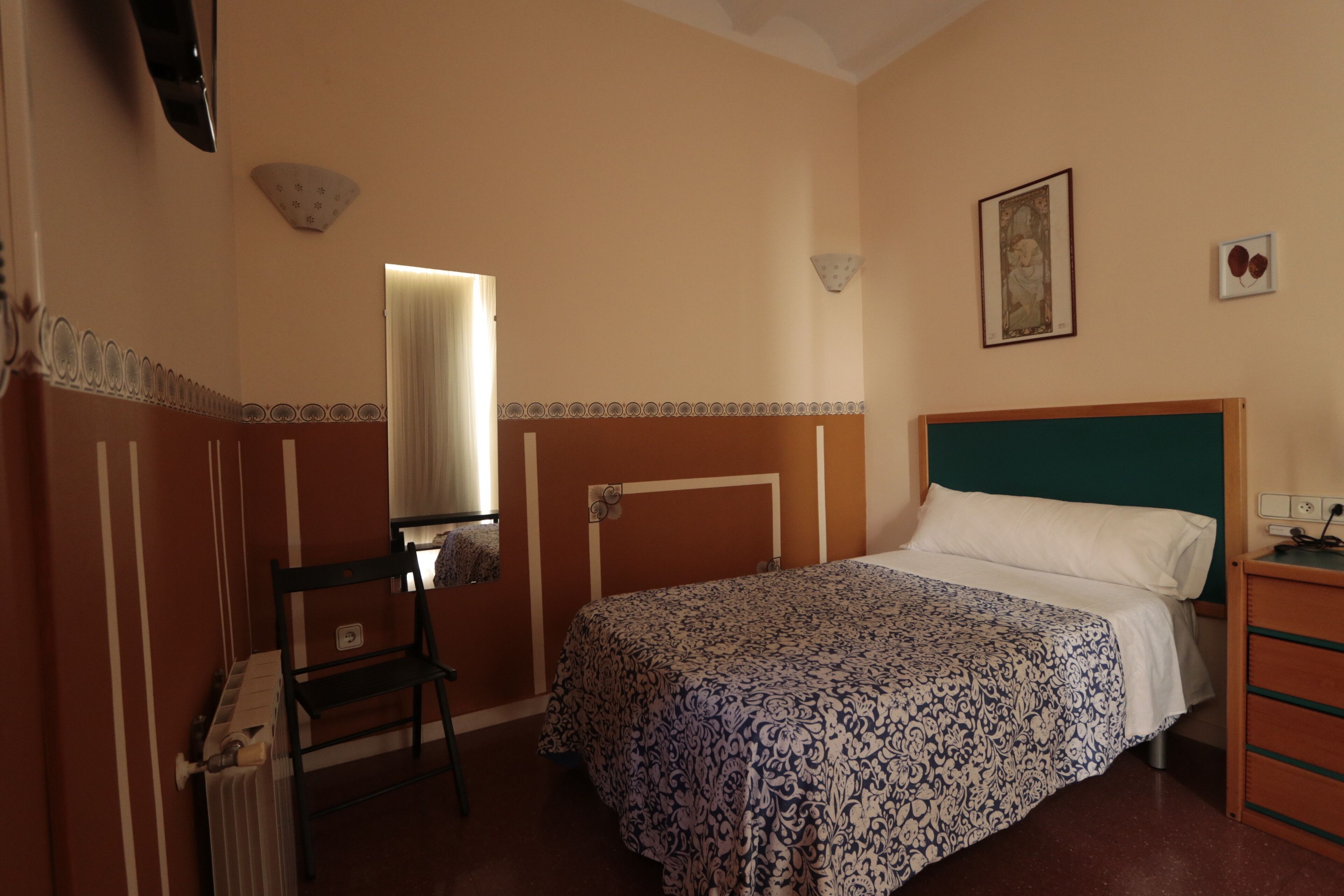 Quarto com cama, cadeira, cômoda e radiador.