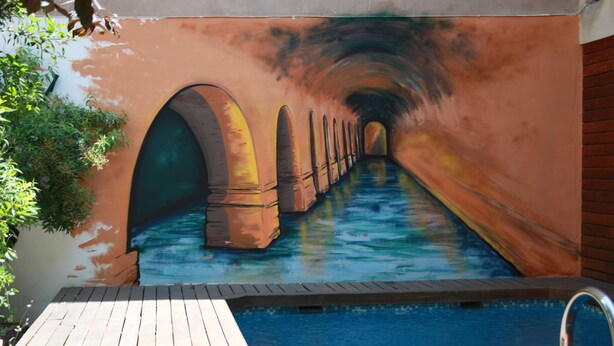 Una piscina con un mural de un túnel submarino.